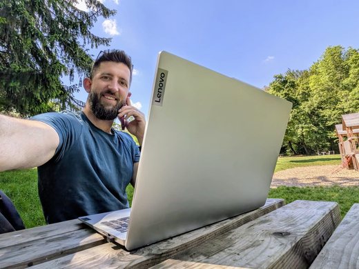 Matthias Gattringer arbeitet im Freien am Laptop und telefoniert dabei mit einem Kunden